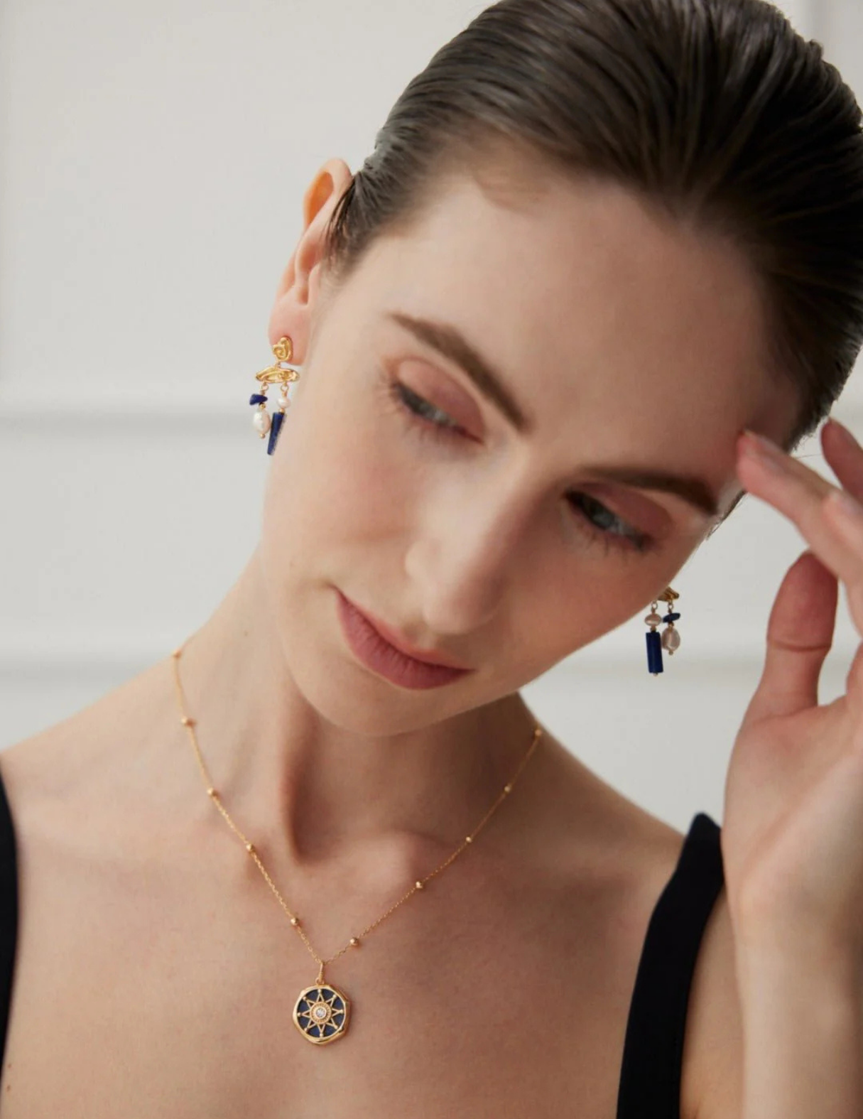 Blauer Lapislazuli-Edelstein mit Perlenohrringen