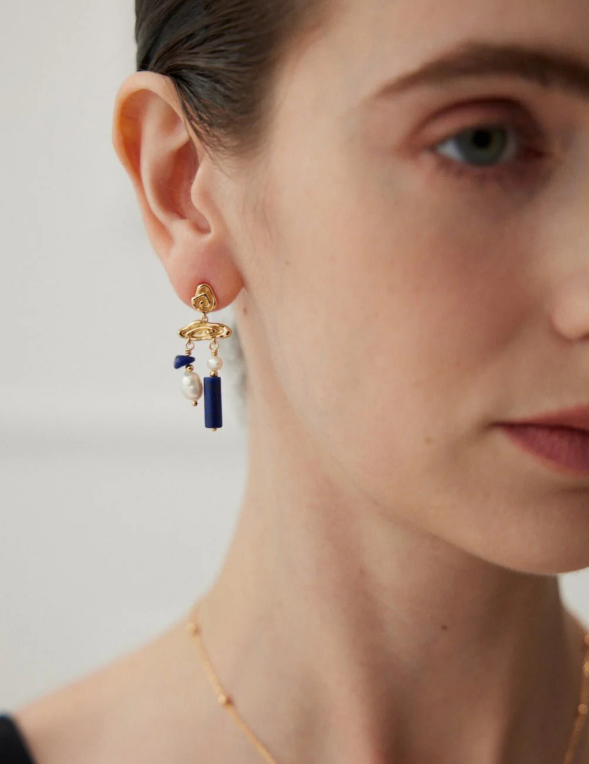 Blauer Lapislazuli-Edelstein mit Perlenohrringen