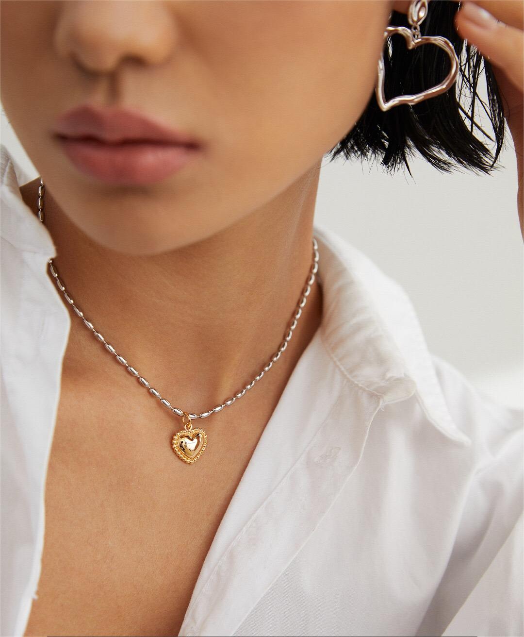 Lifestyle image of model wearing heart pendant necklace, delicate style