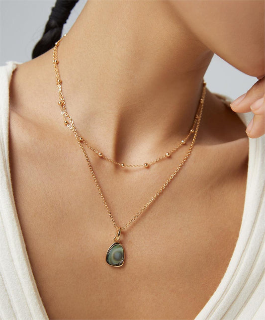 Model wearing Fernovia Design irregular black shell necklace in gold vermeil