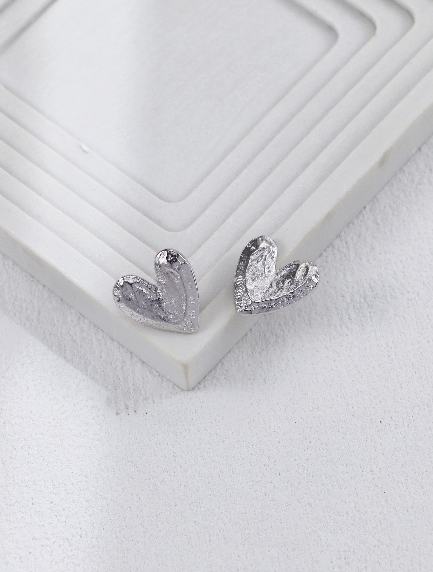 Handcrafted textured heart stud earrings side view